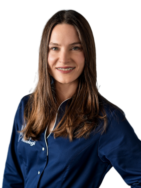 Portret dr Małgorzaty Łodygi, flebologa i kardiologa z Kliniki Flebologii. Uśmiechnięta lekarka o długich brązowych włosach, ubrana w granatowy uniform medyczny z logo kliniki, pozuje na jasnym tle.