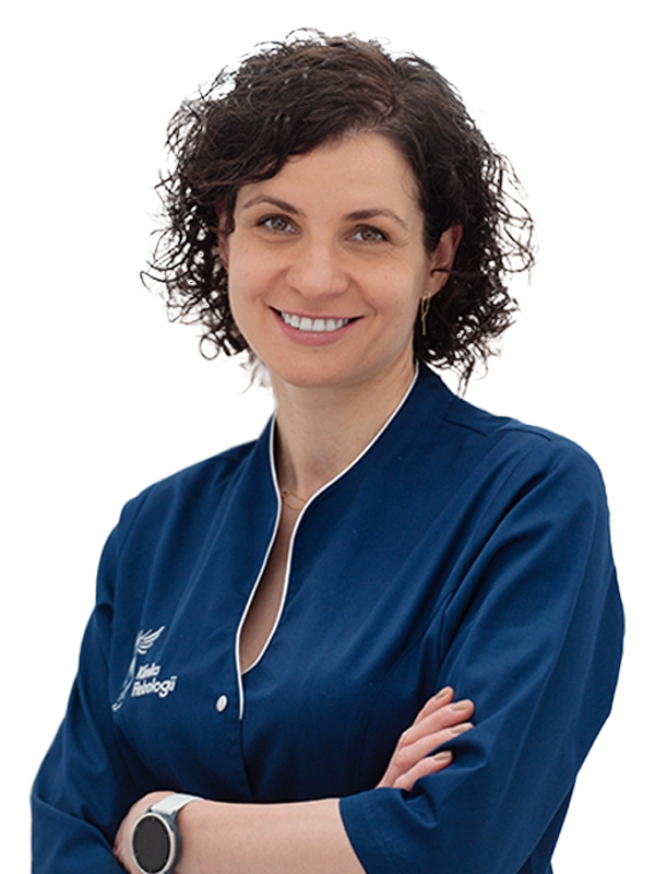 Portret lekarki Emilii Kudlickiej - proktolog z Kliniki Flebologii w Warszawie - w granatowym uniformie medycznym z logo kliniki.